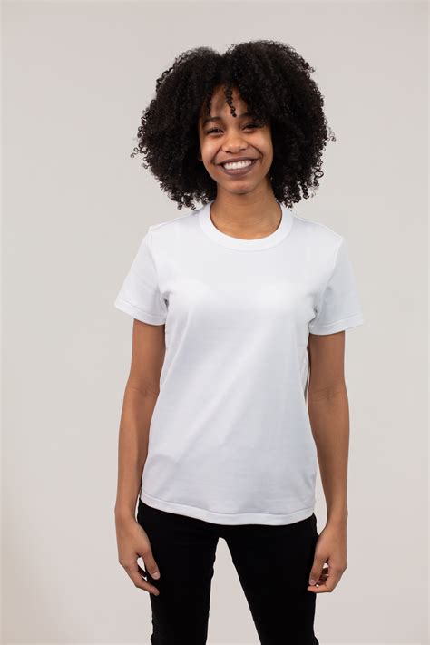 Cheerful black woman wearing white t shirt and pants · Free Stock Photo