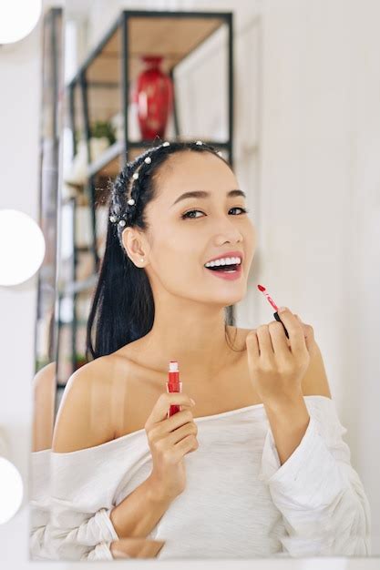 Mujer aplicando lápiz labial rojo Foto Premium