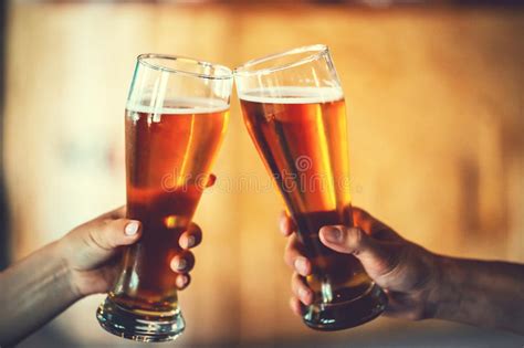 Dos Amigos Que Tuestan Con Los Vidrios De Cerveza Ligera En El Pub Foto