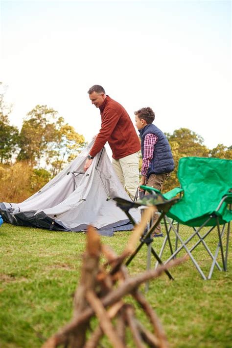 Setting Up Camp A Father And Son Setting Up A Tent Together While