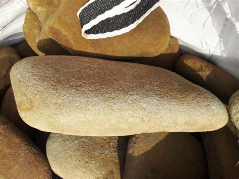 Желтый плоский речной булыжник для мощения