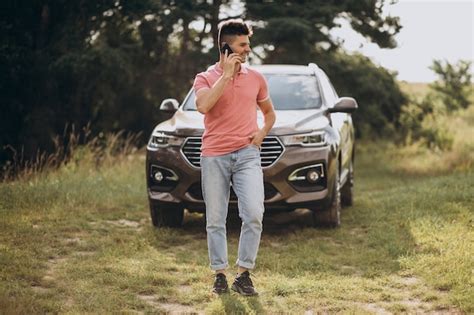 Bel Homme Debout Près De Sa Voiture Dans La Forêt Photo Gratuite