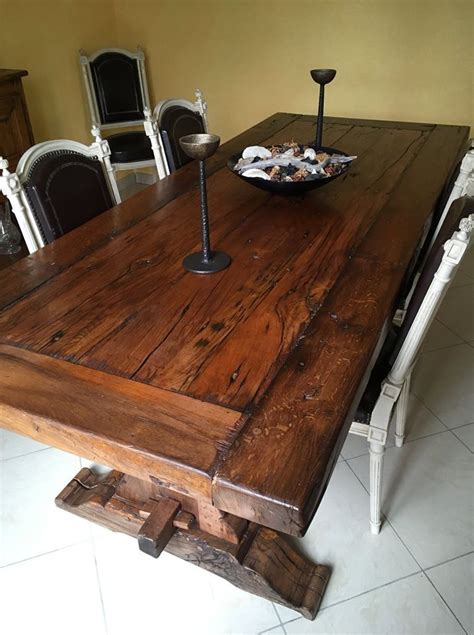 A Wooden Table With Chairs Around It And A Bowl Of Food On The Table Top