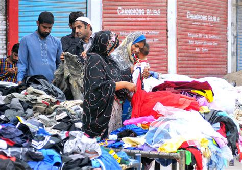 People Selecting And Purchasing Used Clothes From Landa Bazaar