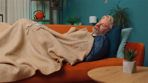 Tired Middle Aged Mature Man Lying Down In Bed Taking A Rest At Home