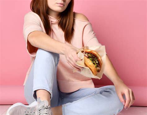 Close Up Portrait Of A Hungry Young Woman Eating Burger Isolated Over