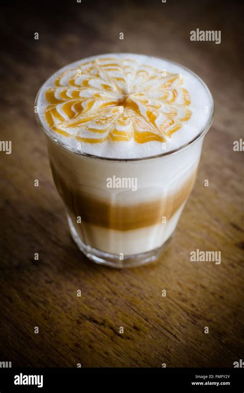 A Glass Of Hot Latte Art Coffee On Wooden Table Stock Photo Alamy