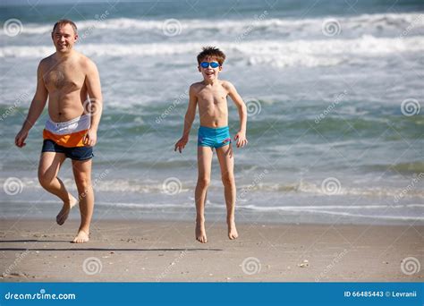 Pai Novo E Filho Que Jogam Na Praia Imagem De Stock Imagem De