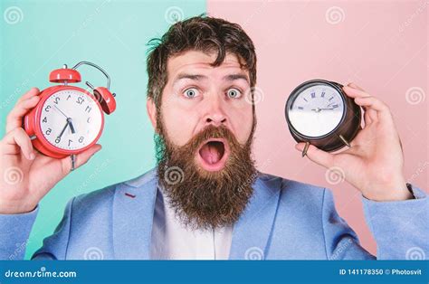 Man Bearded Hipster Hold Two Different Clocks Guy Unshaven Puzzled