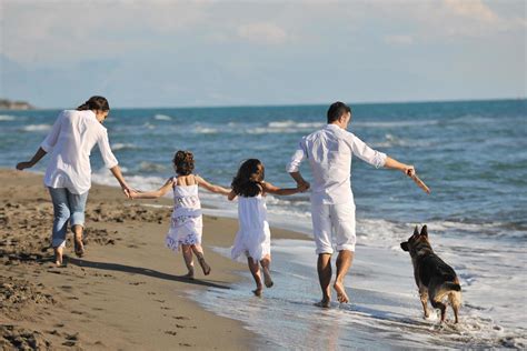 família feliz brincando cachorro na praia 12640687 Foto de stock no