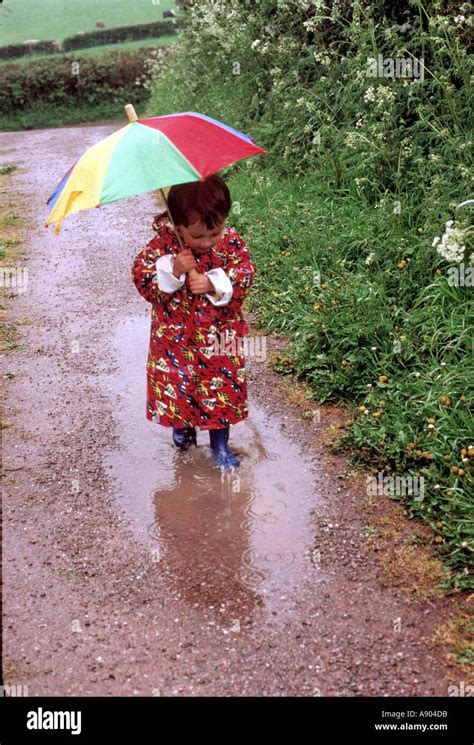 child playing in rain puddle Stock Photo - Alamy