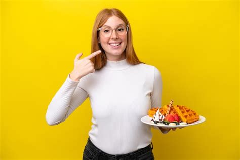 Mulher Jovem Ruiva Segurando Waffles Isolados Em Fundo Amarelo Dando