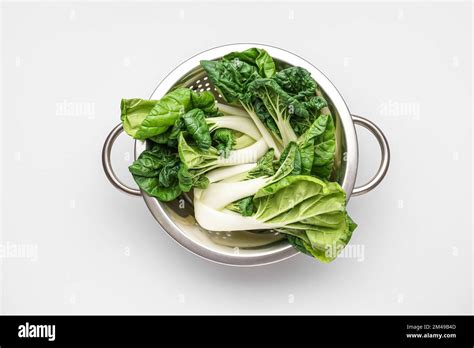 Colander With Fresh Pak Choi Cabbage On White Background Stock Photo