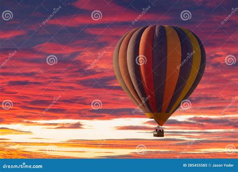 A Hot Air Balloon Rising Under Partly Cloudy Skies During A Brillant