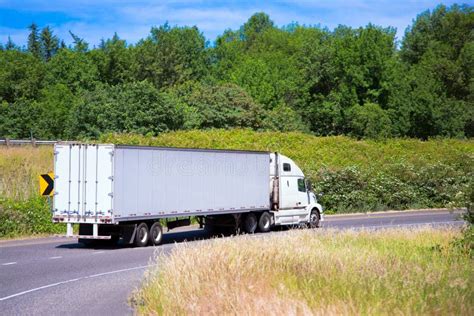 White Semi Truck Modern Trailer on Turn Road Around Green Stock Photo ...