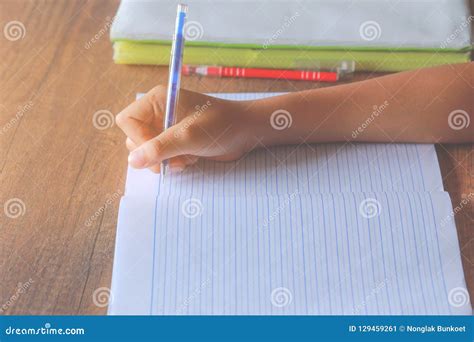 Escritura De La Mano Del Muchacho En El Cuaderno Imagen De Archivo