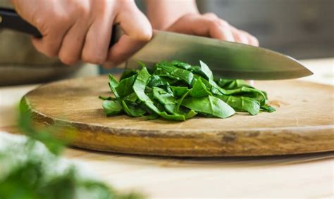 Premium Photo A Woman Is Cutting A Spinach With A Knife