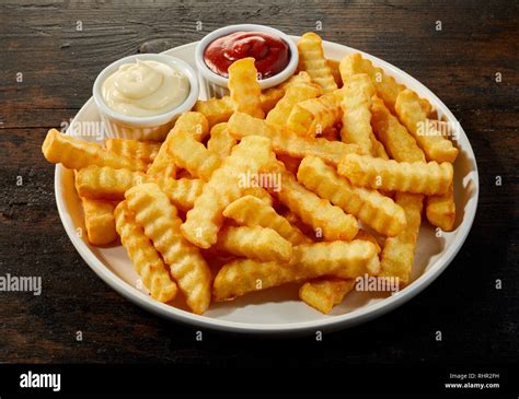 Plate Of Crinkle Cut Crisp Golden French Fries With Mustard Mayonnaise