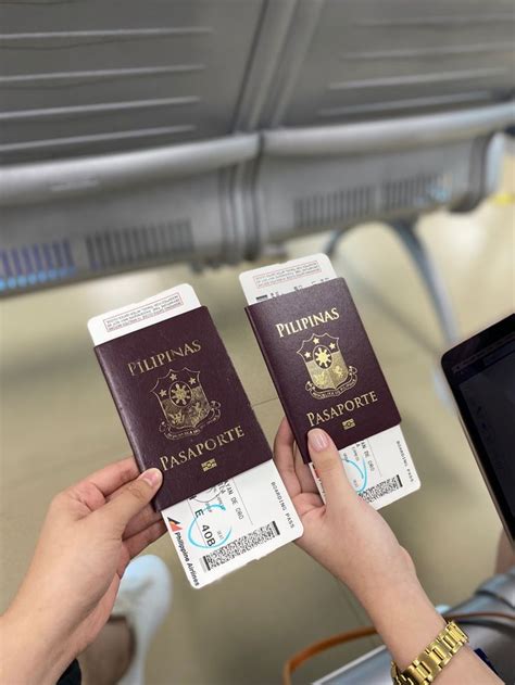 Two People Holding Up Their Passport In Front Of A Laptop