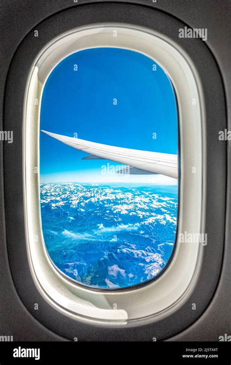 Con vistas a la ventana del avión volando sobre las montañas nevadas de