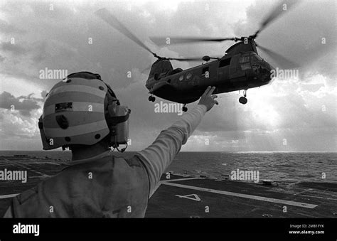 A Flight Deck Crewman Signals To A Ch Sea Knight Helicopter As It