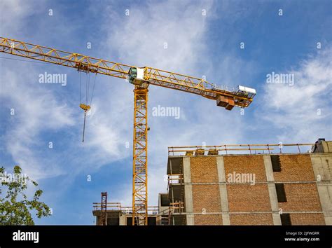 Construction Tower Crane On The Construction Site Of A Modern Brick