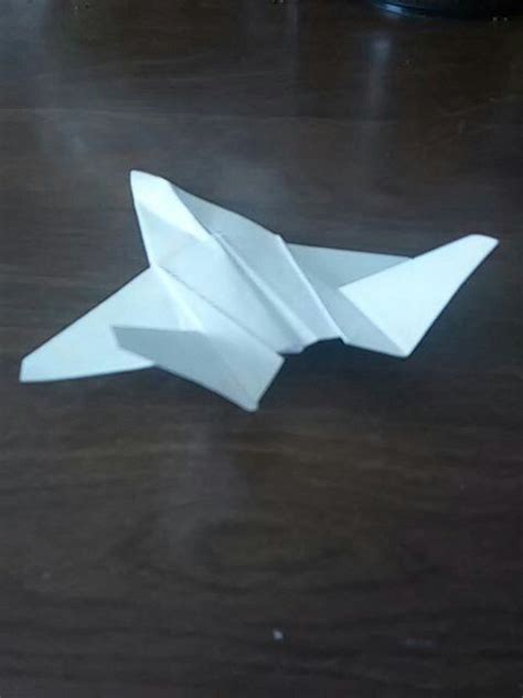 An Origami Airplane Sitting On Top Of A Wooden Table