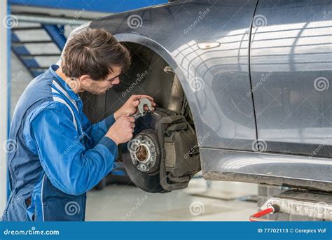 Car Mechanic Examining Brake Disc With Caliper Stock Image Image Of