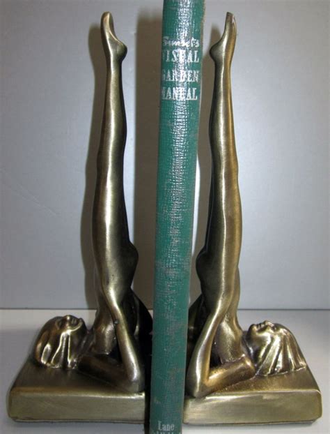 A Book Is Sitting On Top Of A Metal Statue With A Green Book In Front Of It