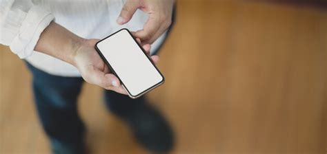 Vista Do Close Up Do Homem Usando O Smartphone De Tela Em Branco Em P