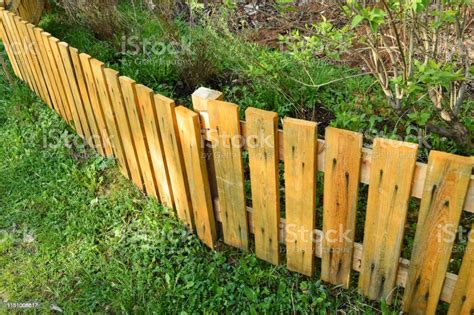 Brown Wooden Fence In Garden Green Background With Parallel Plank Old