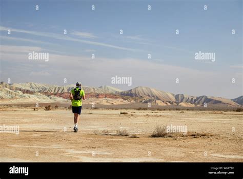 Runner Athlete With Backpack Running On The Wild Trail At Red Mountains