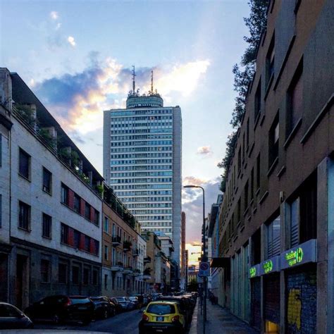 A City Street With Cars Parked On Both Sides And Tall Buildings In The