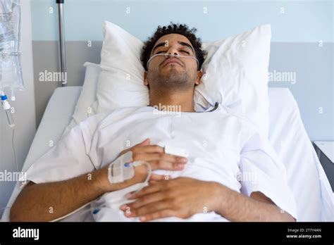 Biracial Male Patient Sleeping In Bed In Sunny Hospital Room Stock