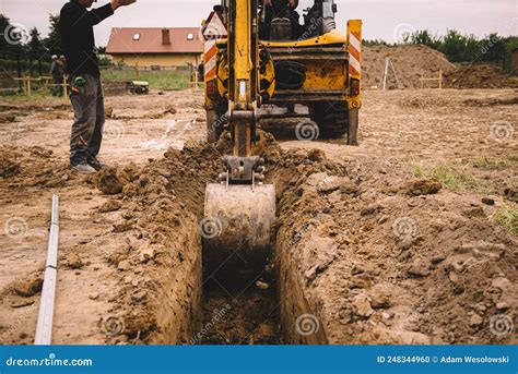 Excavator At House Construction Site Digging Foundations For Modern