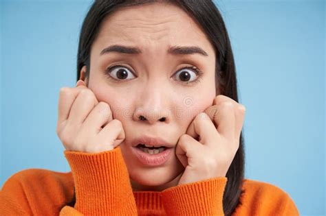 Portrait Of Scared Anxious Young Asian Woman Looks Horrified Stands