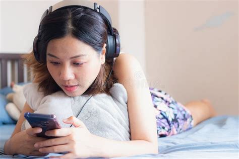 Beautiful Asian Woman Relaxing And Listening To Songs With Smartphone