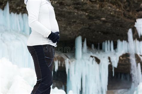 Closeup Of Female Hands Holding Pregnant Belly On Winter Background