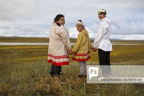 Yupik Inupiag Eskimo Young Man And Yupik Eskimo Girls Stand Overlooking