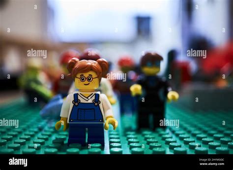 Selective Focus Of A Small Girl Lego Toy With Glasses On A Blurry