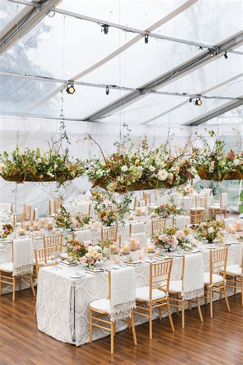 The Tables Are Set Up With White Linens And Floral Centerpieces Along