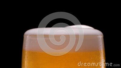 Slow Motion Lager Beer Pouring With Bubbles And Foam On Black