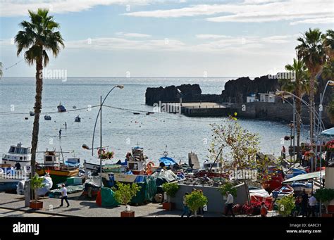 Harbour Area With Fishing Boats And People In Restaurants At Camara De