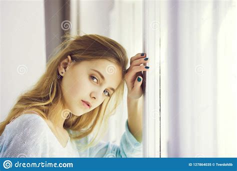 Muchacha Bonita Con Los Ojos Azules Que Se Colocan En La Ventana Imagen