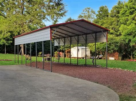 A Metal Carport In The Middle Of A Grassy Area With Trees And Bushes