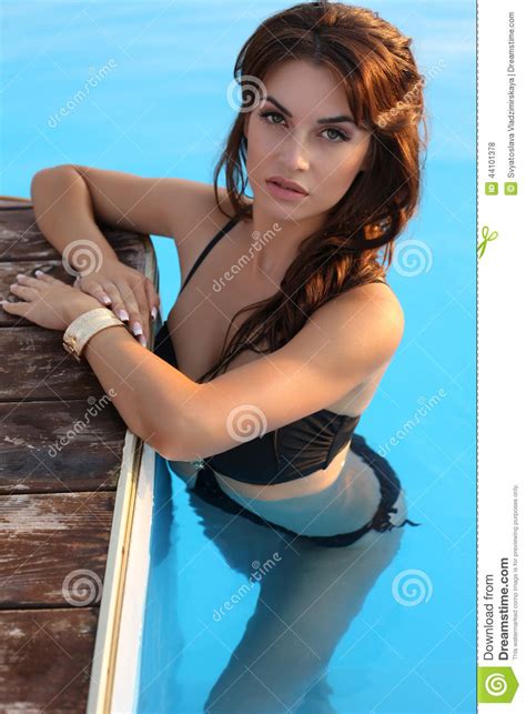 Girl With Dark Hair In Bikini Posing In Swimming Pool Stock Photo