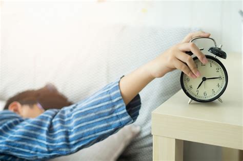 Unos niños se despiertan con un despertador en el dormitorio Foto Premium