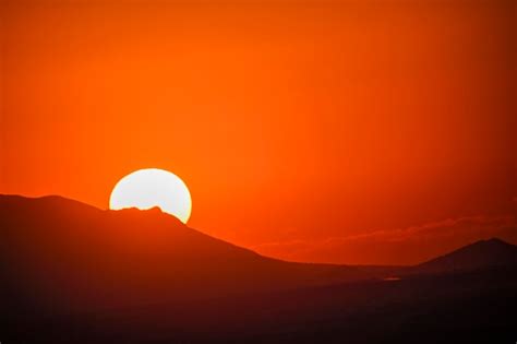 Premium Photo | The sun rising over the horizon of the mountains