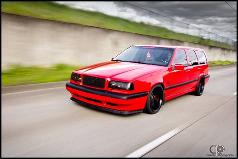 red volvo car driving   road