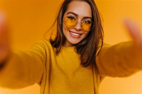 Heureux Jeune Femme Aux Cheveux Bruns Faisant Selfie Sur Mur Jaune Avec